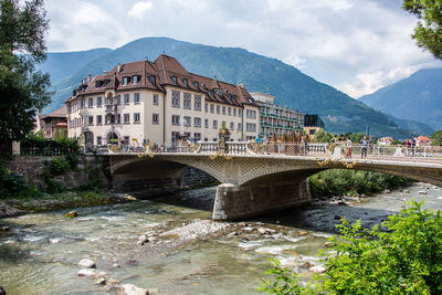 Arch bridge over river against buildings