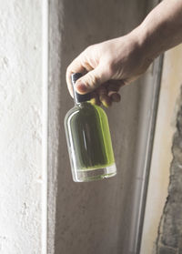 High angle view of hand holding glass bottle