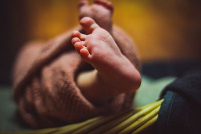 Low section of baby girl on bed at home