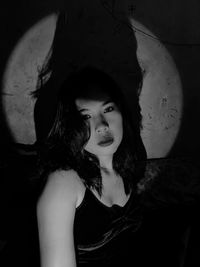 Portrait of young woman against wall