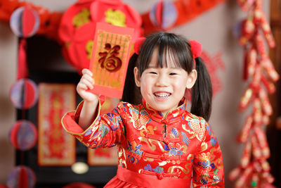 Chinese young girl traditional dressing up with a fu means lucky red envelope