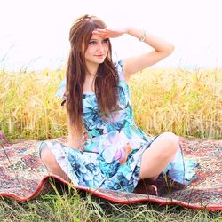 Beautiful woman looking away while sitting at farm