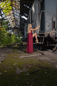 Portrait woman standing by abandoned train doorway