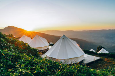 Tent on field against sky during sunset