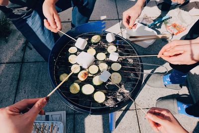 Low section of people holding food on table