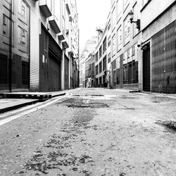Empty road amidst buildings in city