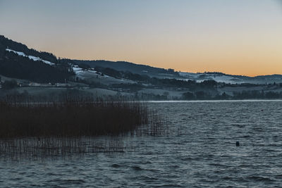 Scenic view of lake against sky during sunset