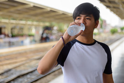 Portrait of a serious young man drinking water