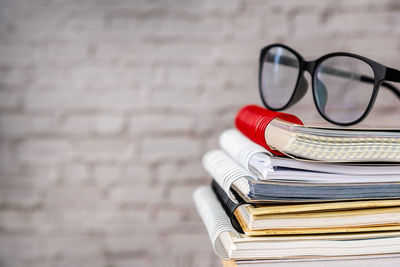 Close-up of books on table against wall