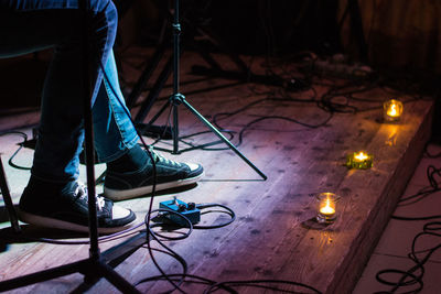 Low section of man photographing illuminated stage