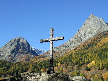 Cross on mountain against clear blue sky