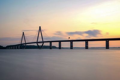 Suspension bridge against sky sunset
