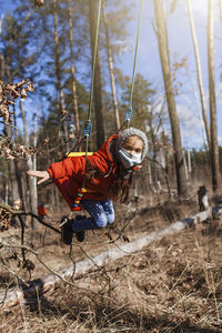 Man with rope on land in forest