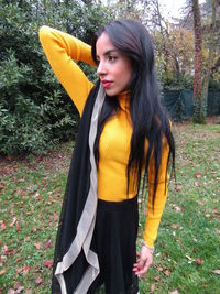 Beautiful young woman looking away while standing on land