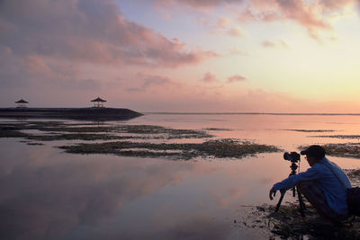 Man on beach against sky during sunset