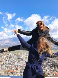 Low angle view of young woman against sky in city