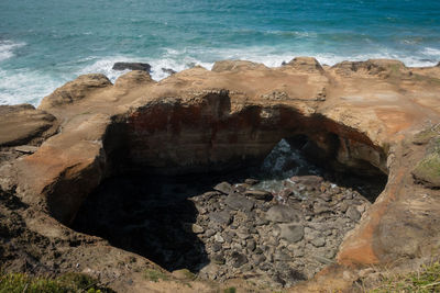 High angle view of rock formation at beach against sky