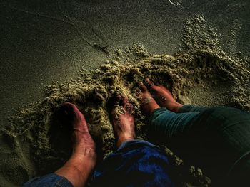 Low section of man standing on beach