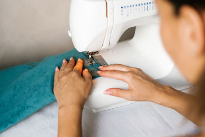 Sewing machine with the hands, close-up. individual designer tailoring.