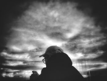 Low angle view of silhouette woman standing against sky