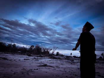 Silhouette man standing on snow covered land against sky