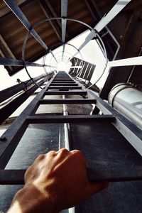 High angle view of person hand on railroad track
