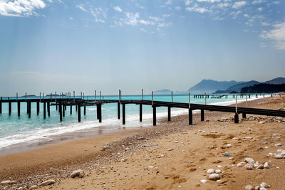 Pier on beach against sky