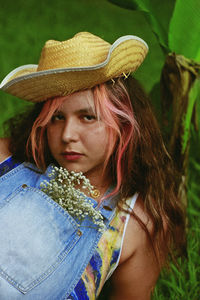 Portrait of woman wearing hat lying at park