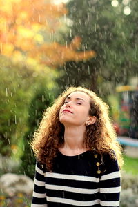 Portrait of a smiling young woman in rain