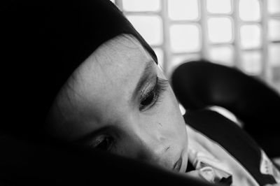 Close-up of thoughtful boy relaxing on bed at home