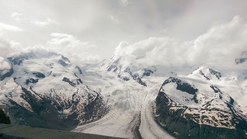 Scenic view of mountains against cloudy sky