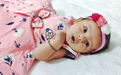 High angle portrait of cute baby lying on bed