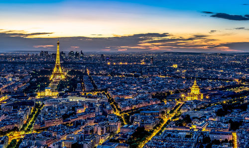 Eiffel tower amidst cityscape at dusk