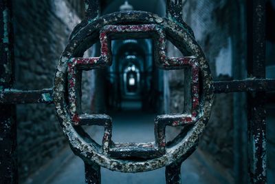 Close-up of plus sign on metallic grate in corridor at eastern state penitentiary