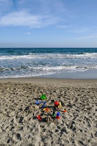 Scenic view of an empty, sandy beach with colorful beach toys, laigueglia, savona, liguria, italy 