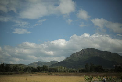 Scenic view of field and mountains against sky