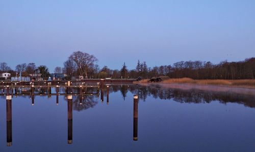 Reflection of trees in lake against clear sky