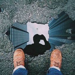 Low section of man standing on tiled floor