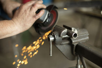 Midsection of man working on metal