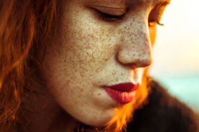 Close-up portrait of redhead woman looking away