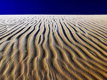 Sand dune in desert against clear sky