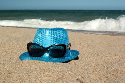 Scenic view of hat and sunglasses on shore
