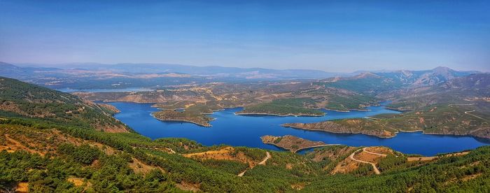 High angle view of lake and mountains against blue sky