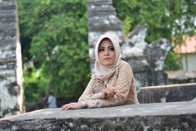 Portrait of a young woman sitting outdoors