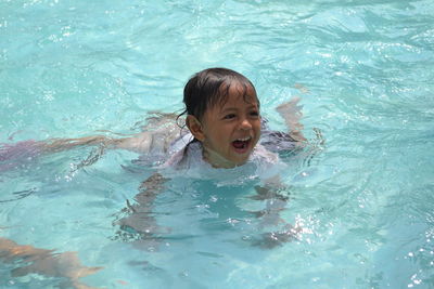 Portrait of smiling boy swimming in pool