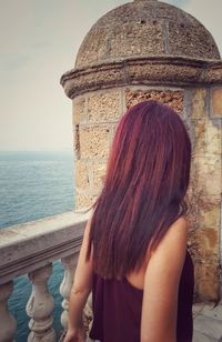 Rear view of woman looking at sea against sky