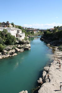 High angle view of people by river against sky on sunny day