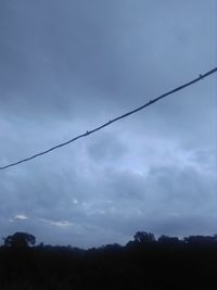 Low angle view of silhouette trees against sky