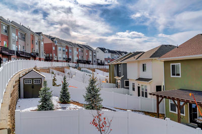 Houses and buildings in city against sky