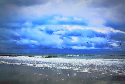 Scenic view of sea against cloudy sky